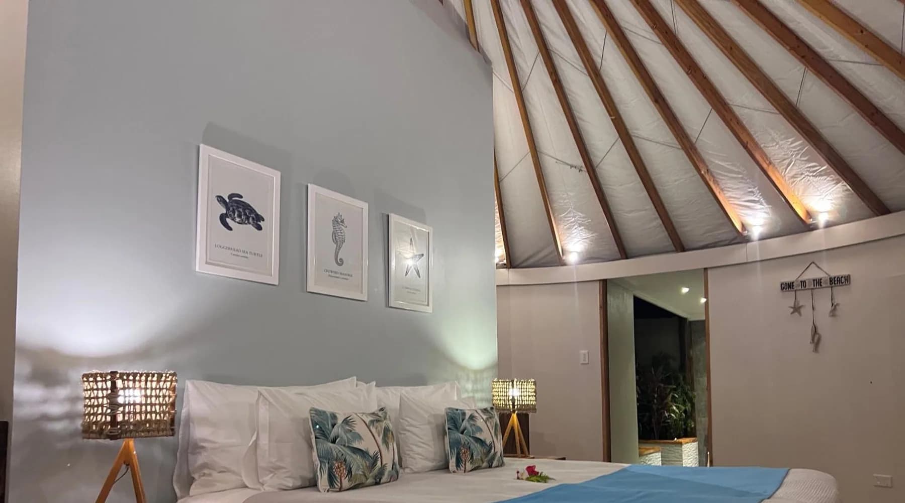 Guest room with an exposed timber ceiling and blue-and-white bedding